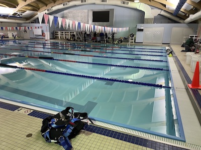 A pool with scuba gear on the edge